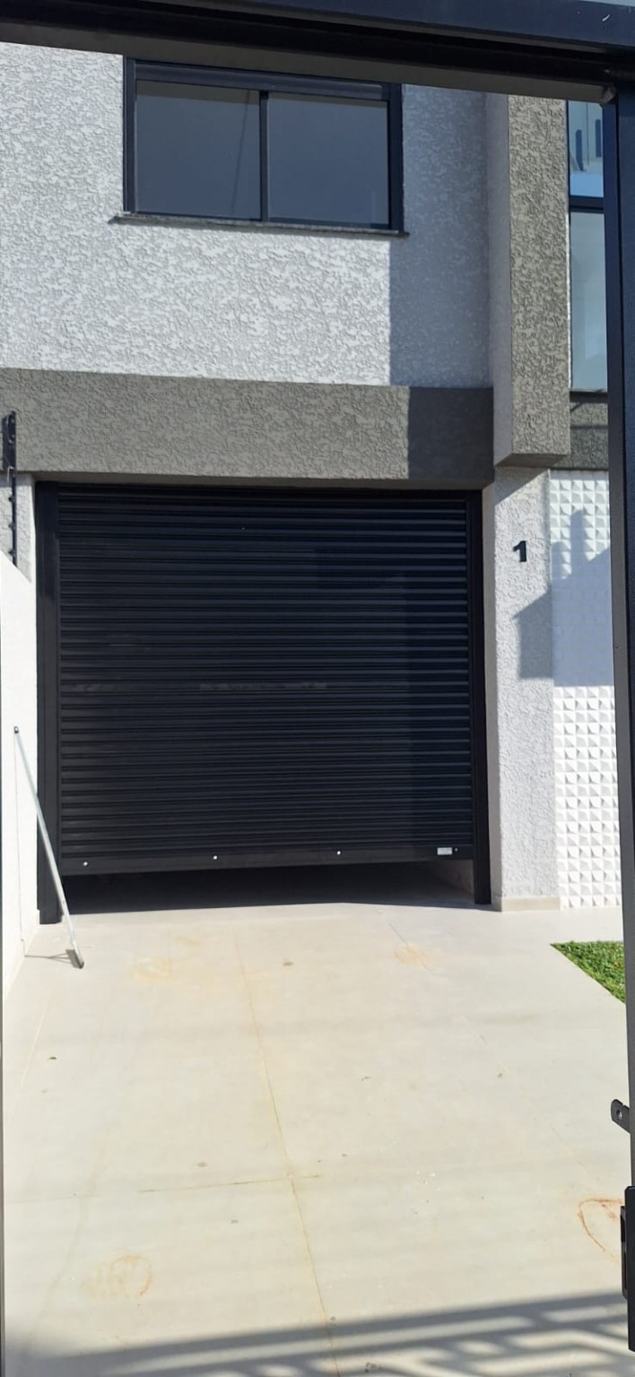 Porta de enrolar automatizada preta em garagem residencial